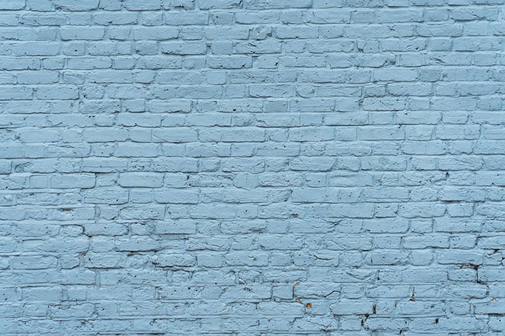 Un muro di mattoni blu con un orologio su di esso