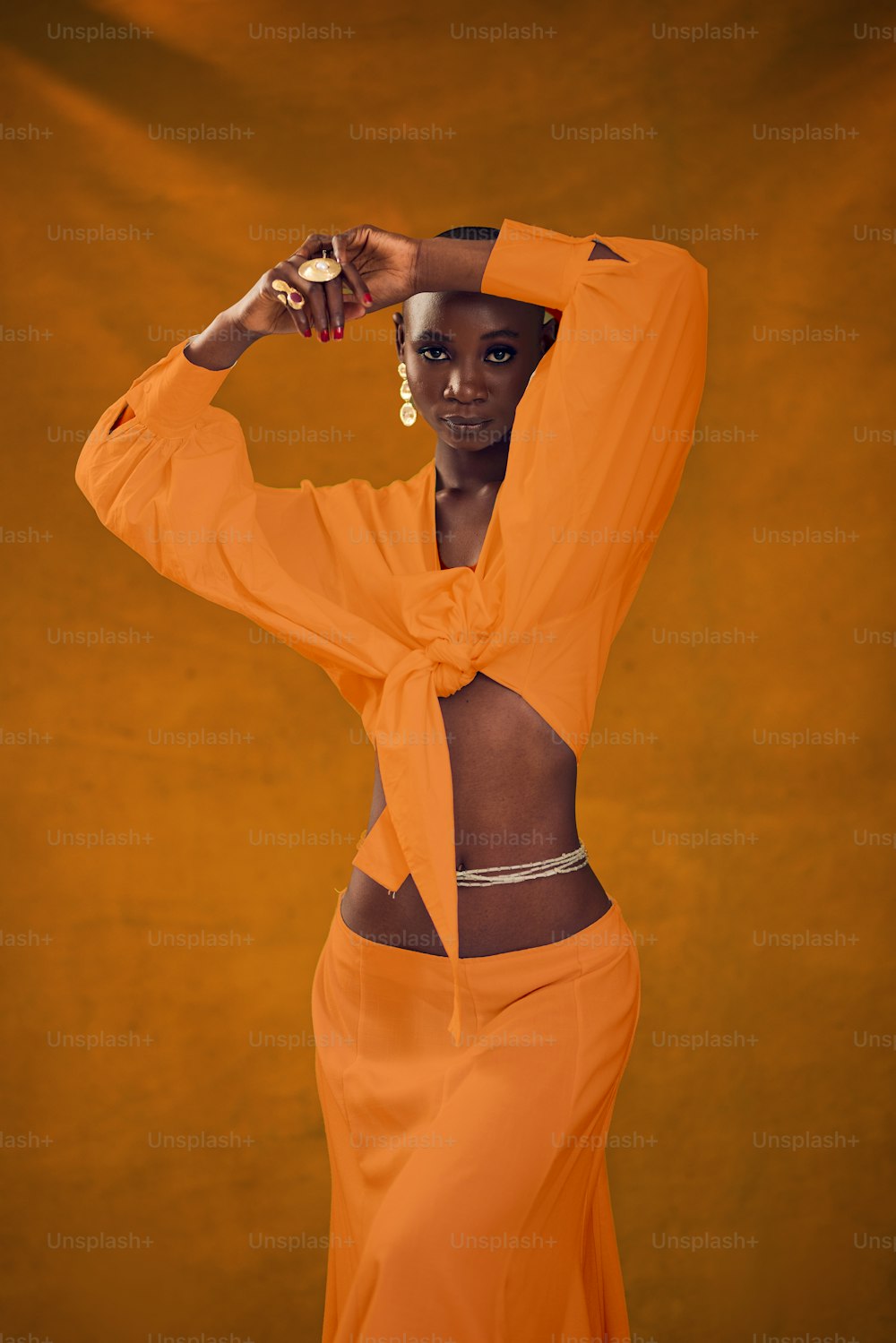 a woman in an orange outfit poses for a picture