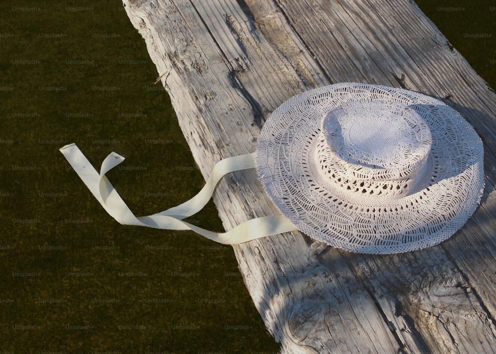 un chapeau blanc posé sur une table en bois