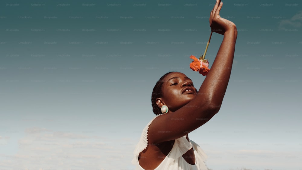 Una mujer sosteniendo una flor en el aire