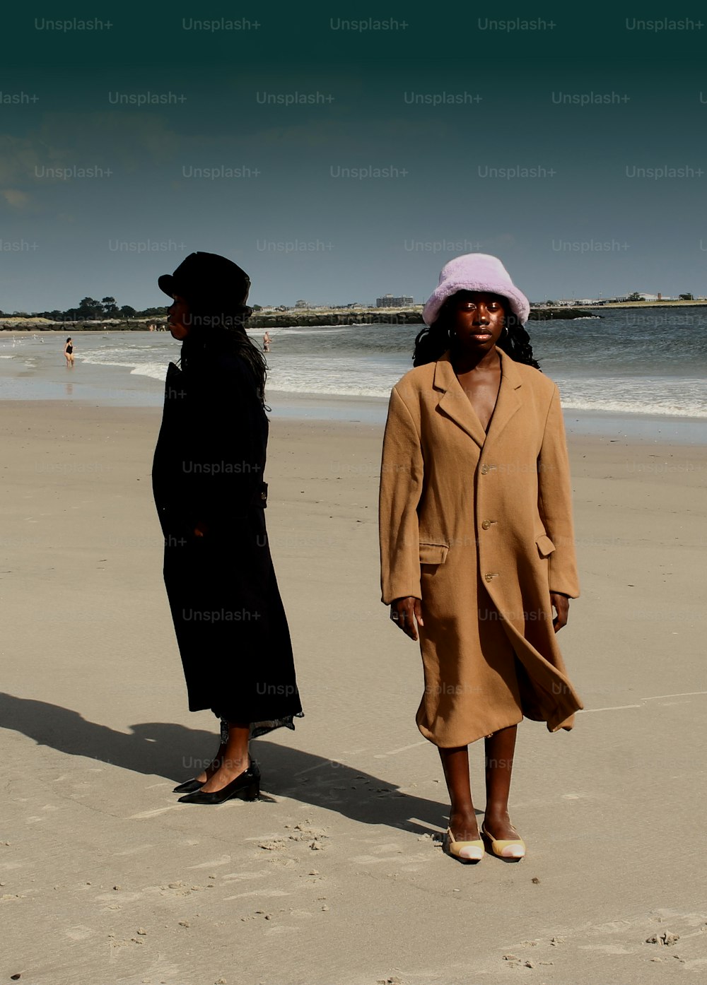 Un paio di donne in piedi sulla cima di una spiaggia sabbiosa