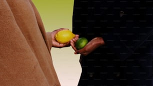 a man holding a lemon and a lime in his hand
