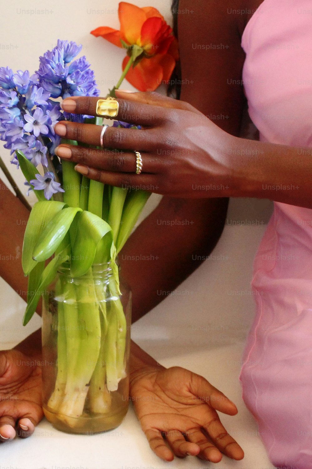 Una mujer arreglando flores en un jarrón sobre una mesa