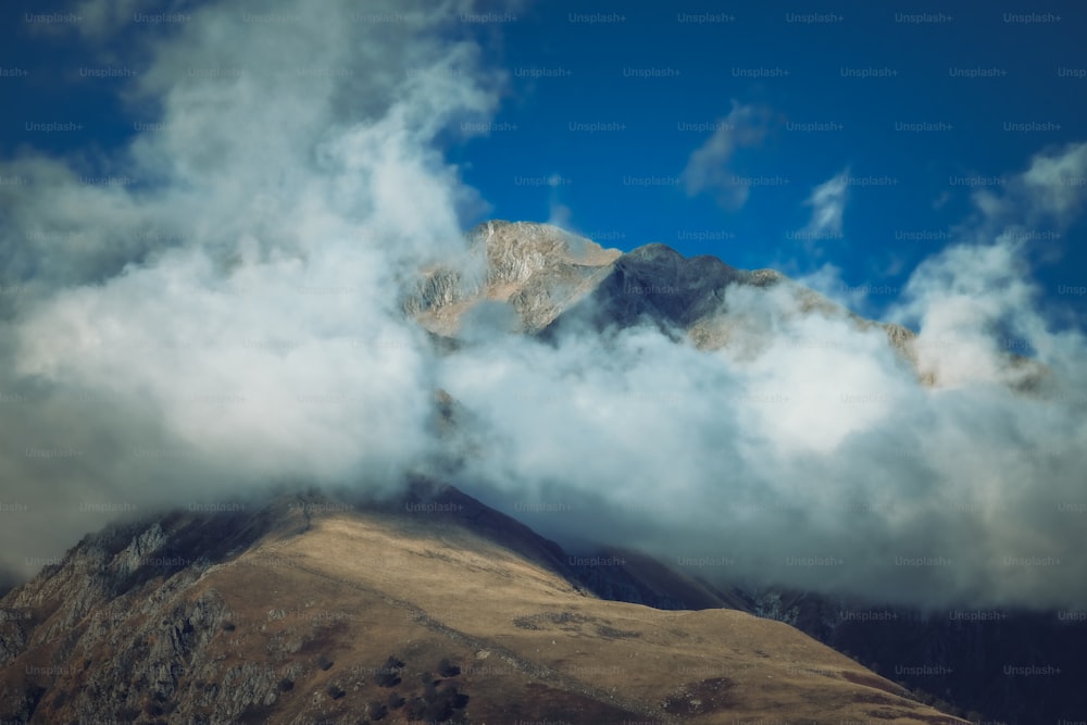 Ein wolkenverhangener Berg mit blauem Himmel im Hintergrund