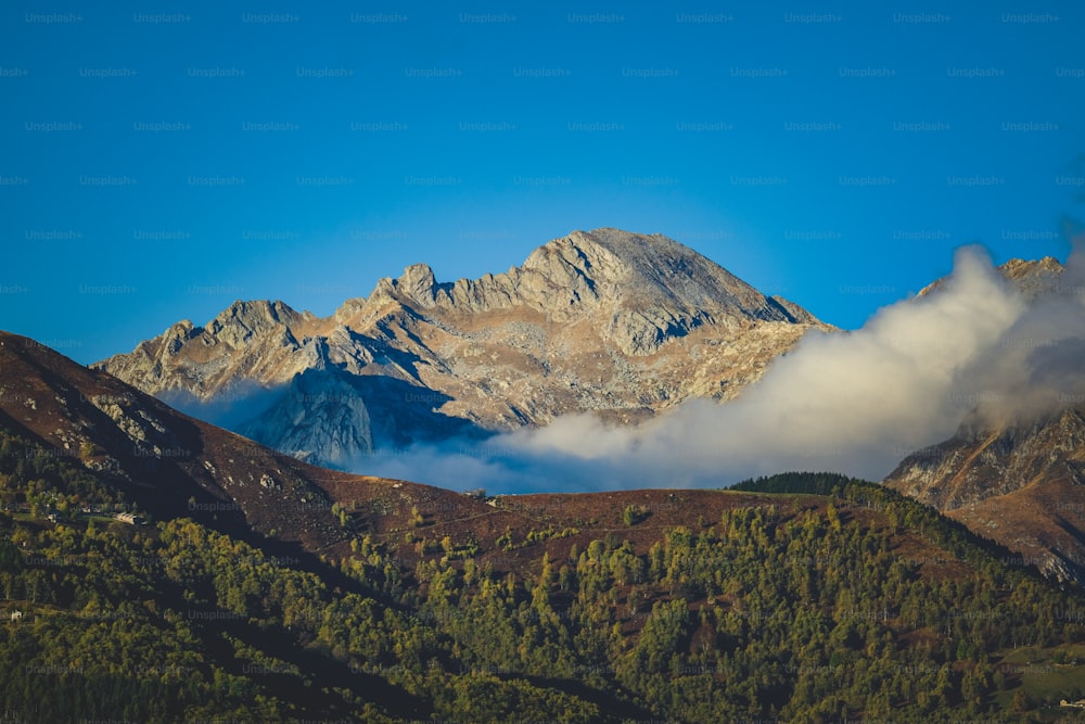 une vue d’une chaîne de montagnes avec des nuages bas au premier plan