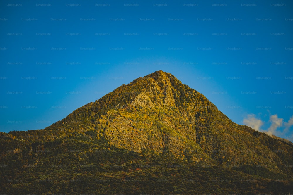uma montanha muito alta com um céu azul no fundo