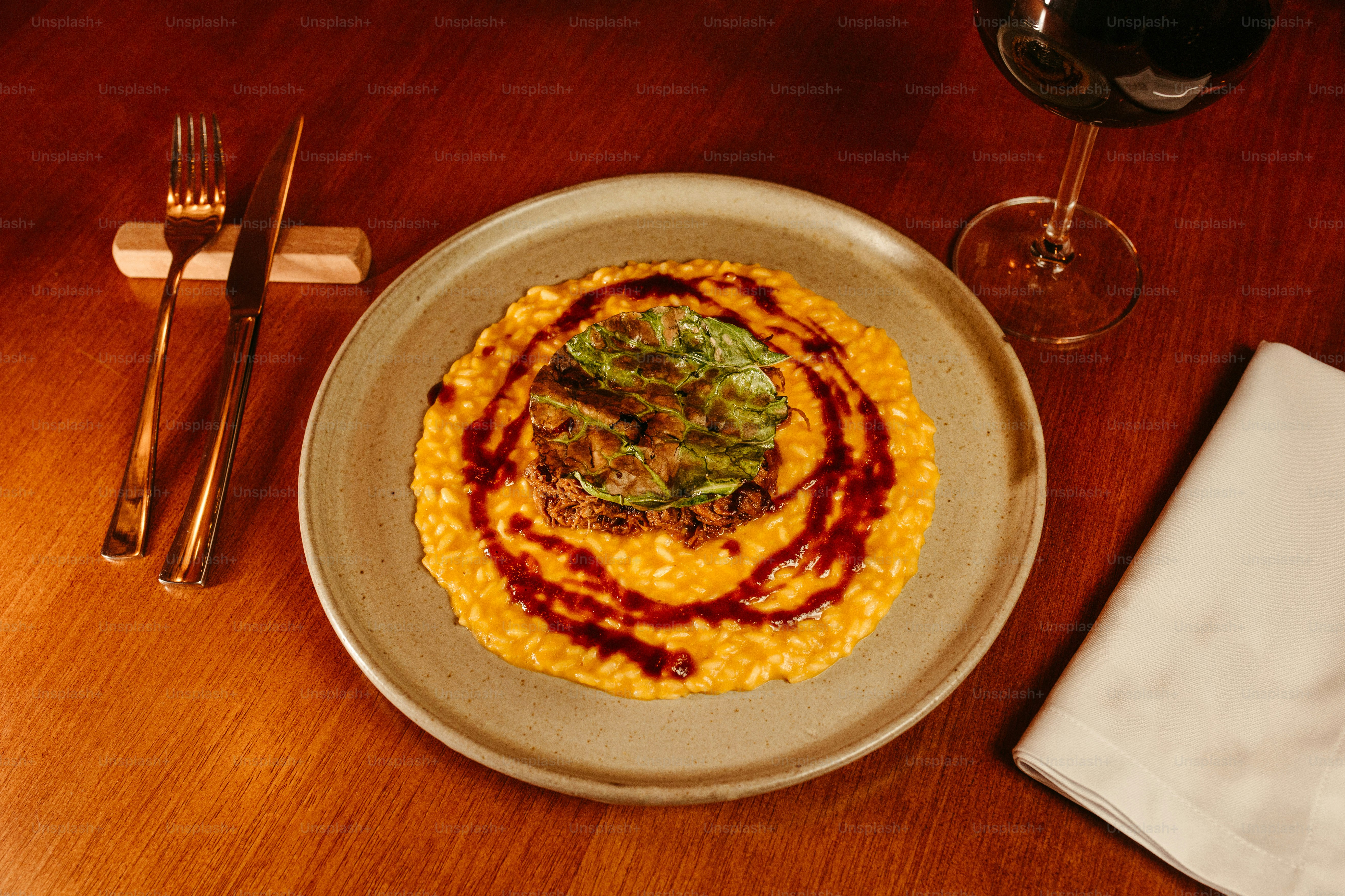 um prato de comida e um copo de vinho sobre uma mesa