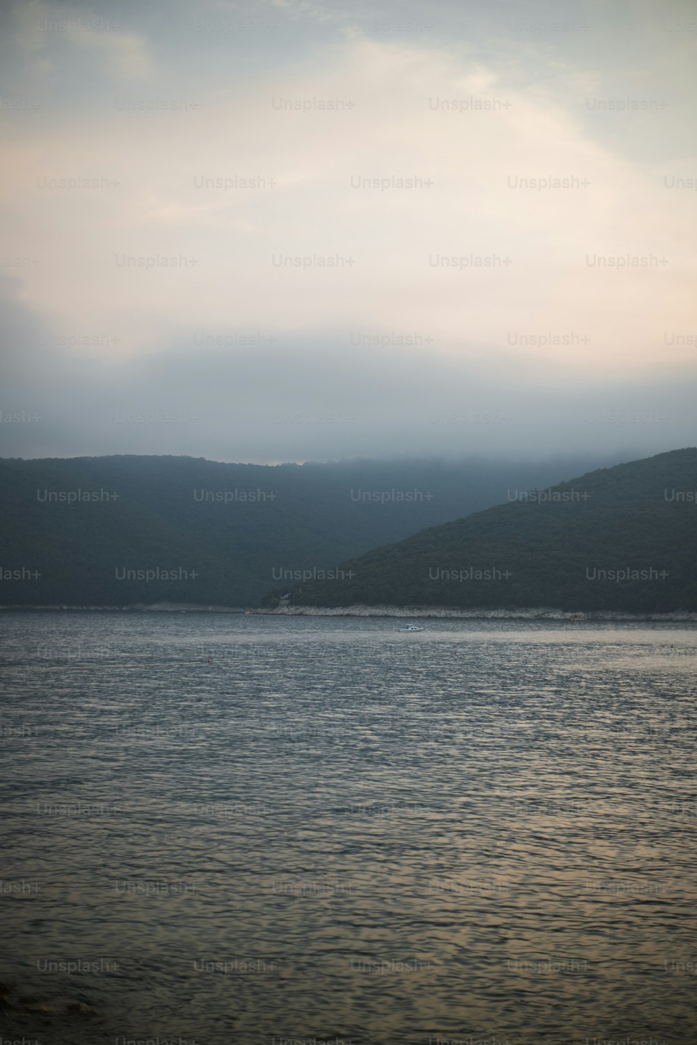 a large body of water with hills in the background