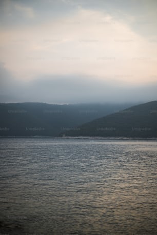 a large body of water with hills in the background
