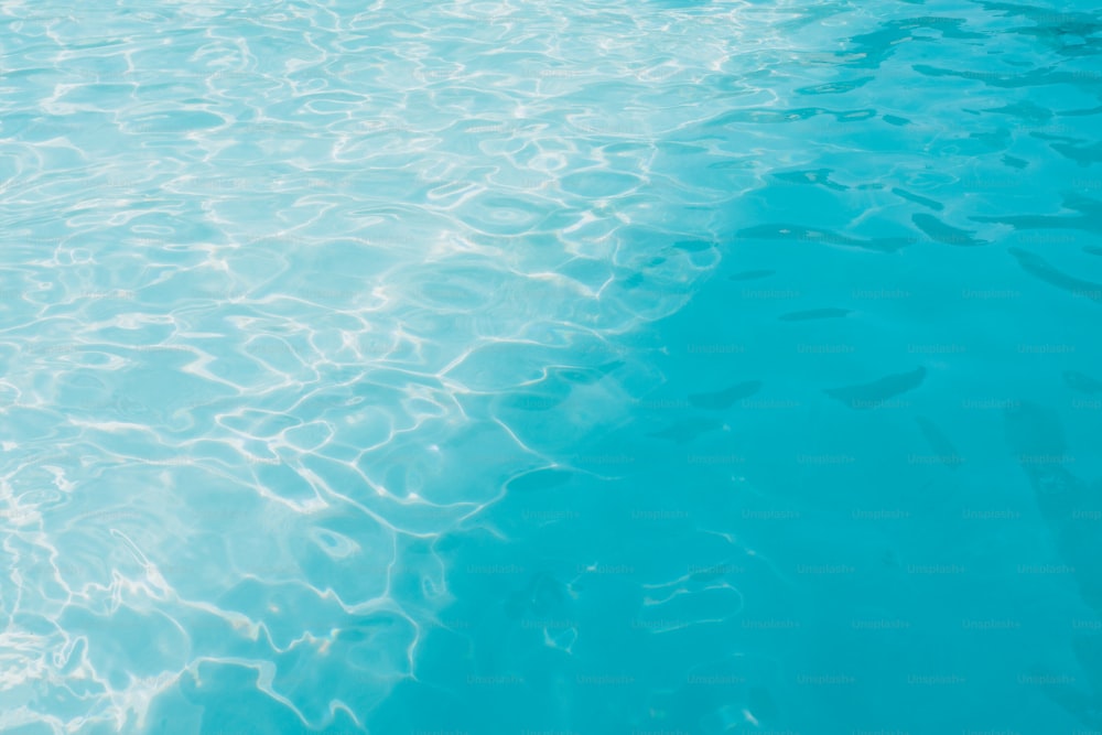 una piscina azul con agua clara y un barco al fondo