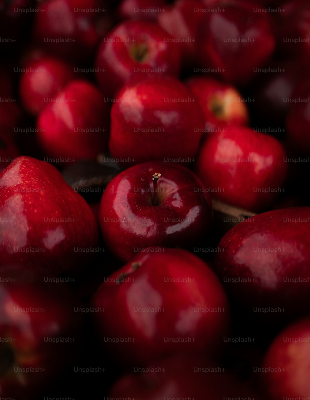 un tas de pommes rouges assises les unes à côté des autres