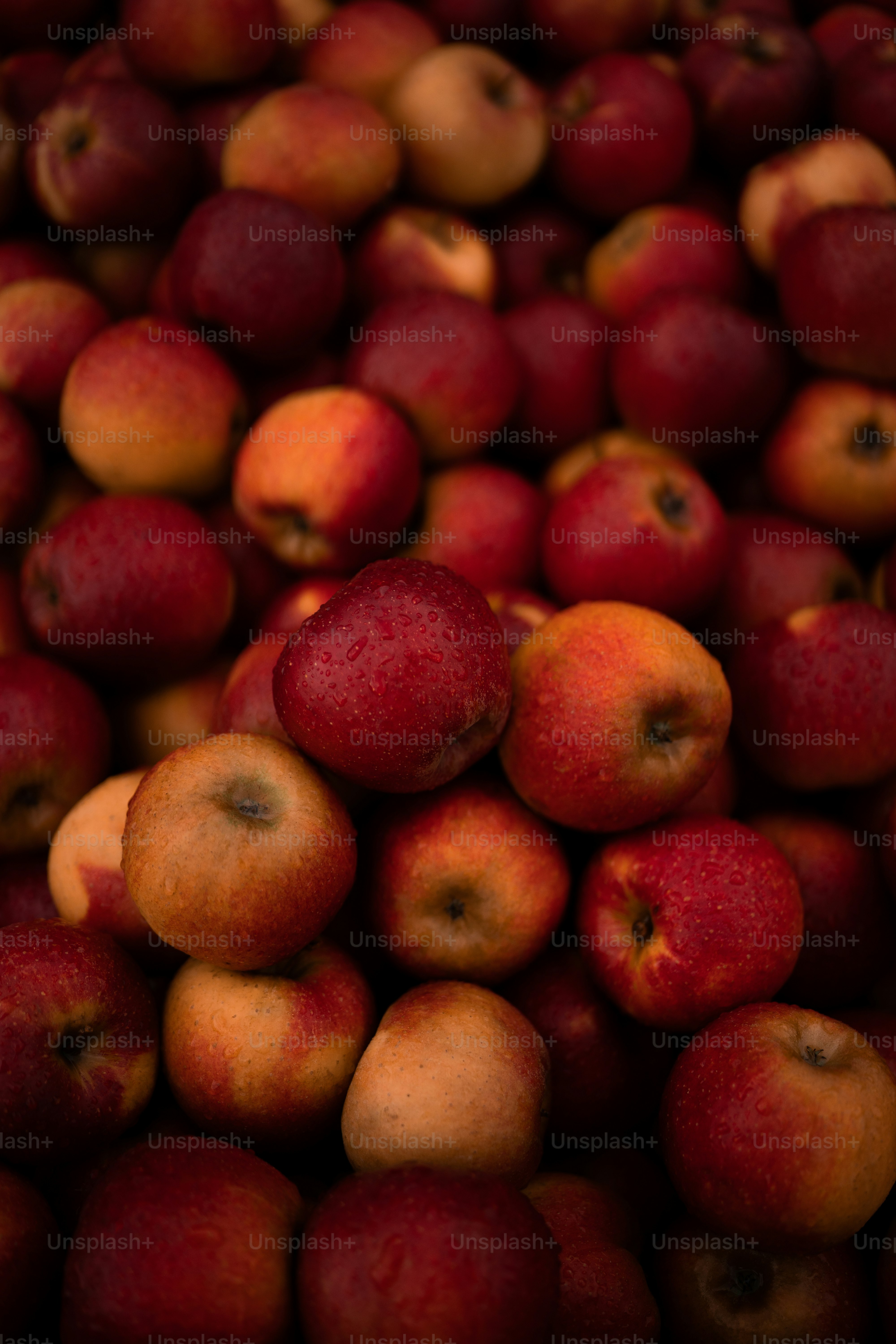 a pile of red apples sitting on top of each other