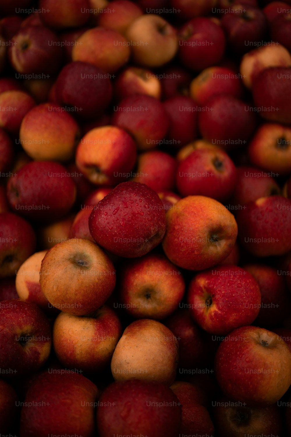 a pile of red apples sitting on top of each other