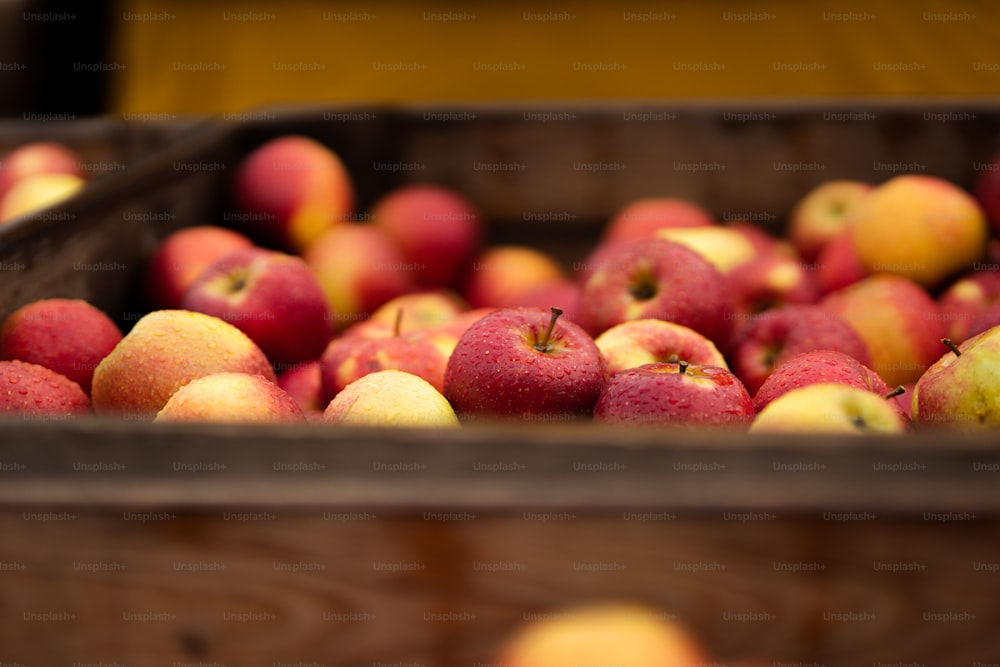 a wooden box filled with lots of red and yellow apples