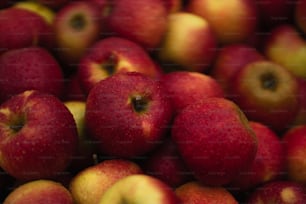 a pile of red apples sitting on top of each other