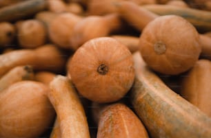 a pile of oranges and other fruits and vegetables