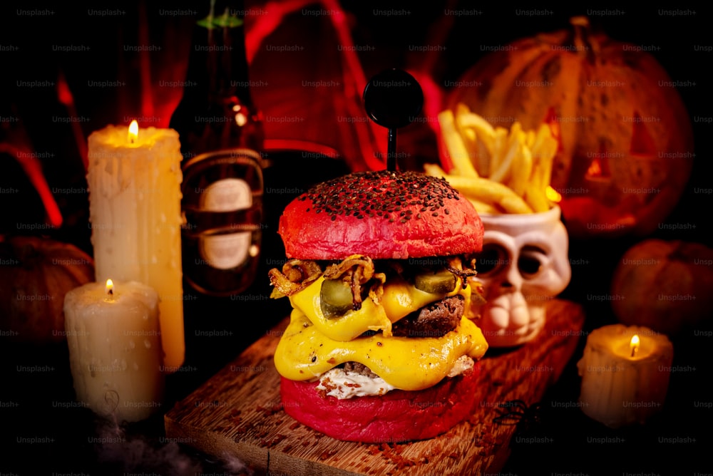 a cheeseburger on a cutting board with candles and candles