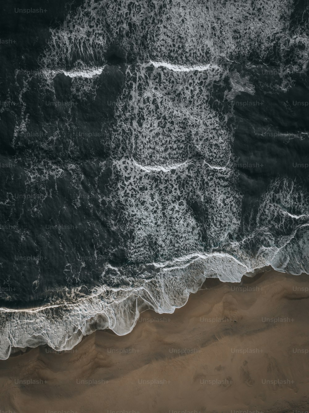 una vista aerea di una spiaggia con onde e sabbia