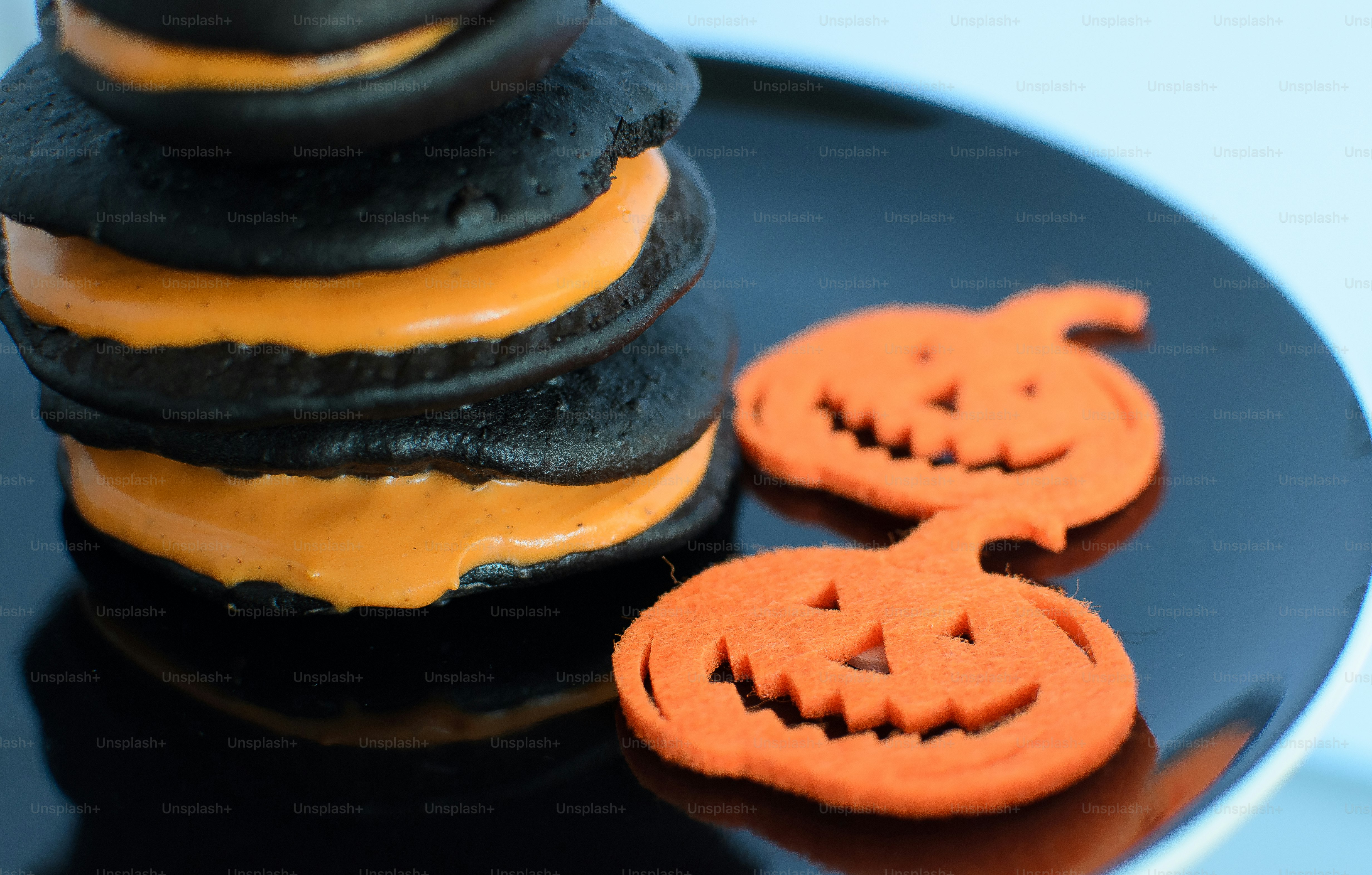 a black plate topped with cookies covered in frosting