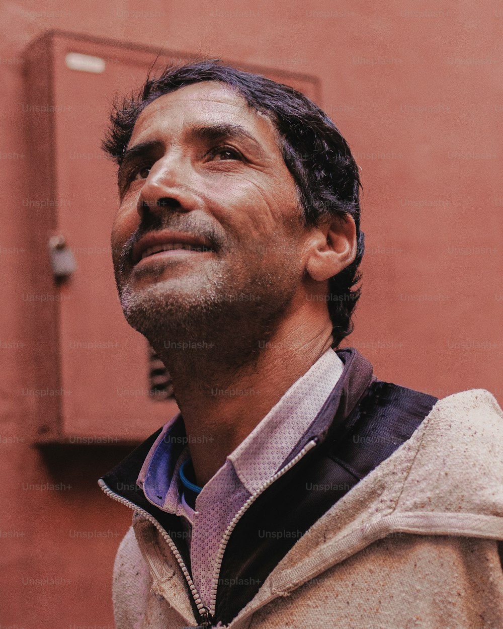 a man standing in front of a red building