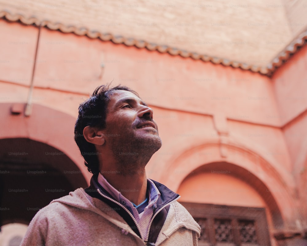 Un homme debout devant un immeuble levant les yeux