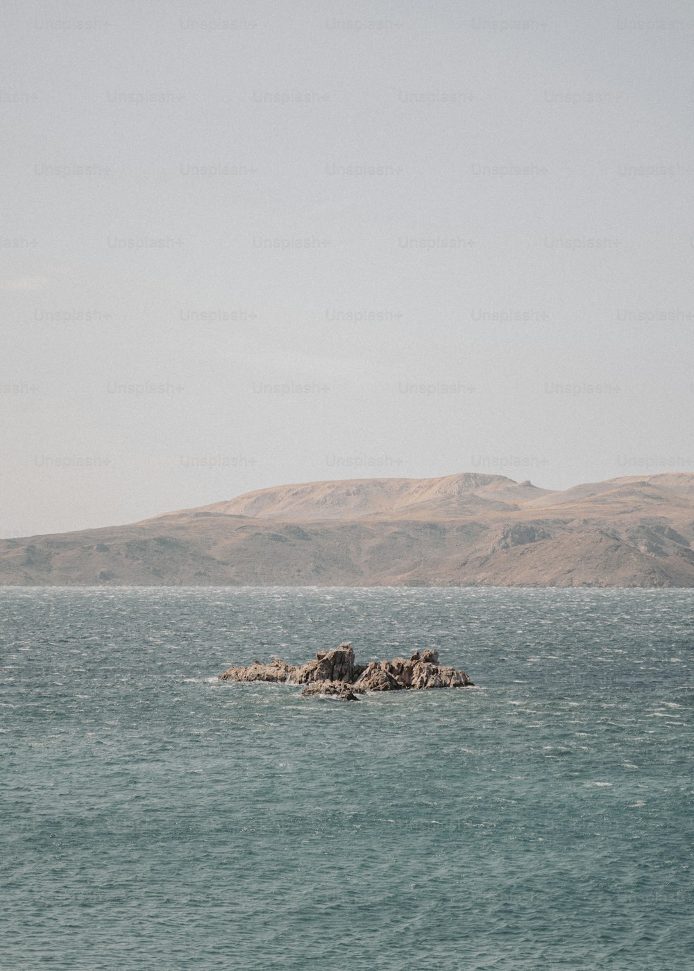 a large body of water with a mountain in the background