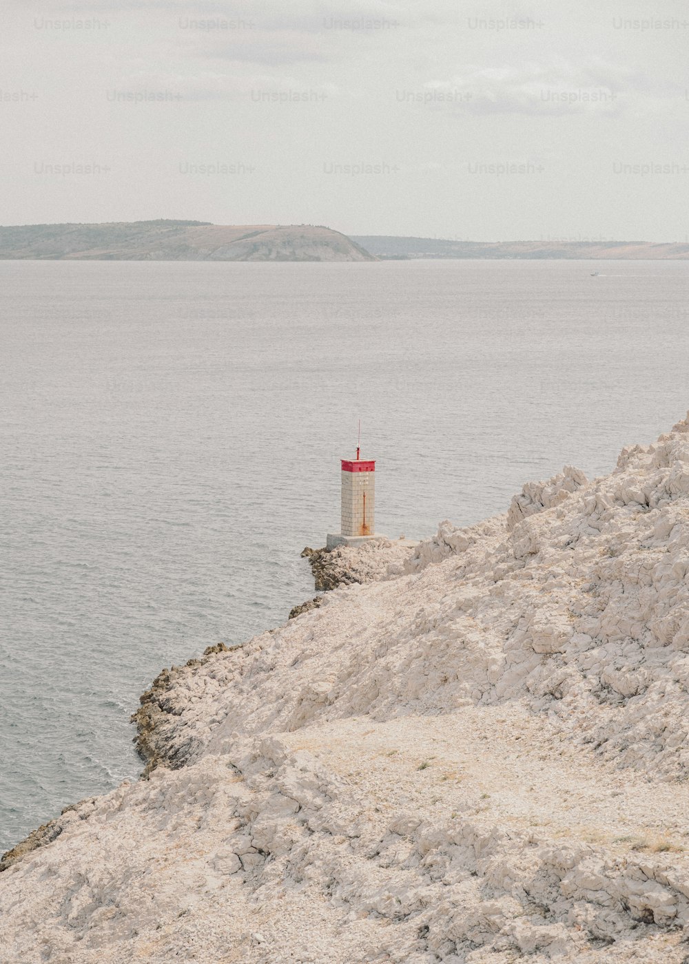 崖の上に座る赤と白の灯台
