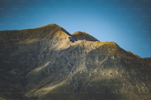 a mountain range with a blue sky in the background