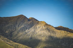 Una vista de una cadena montañosa con un cielo azul en el fondo