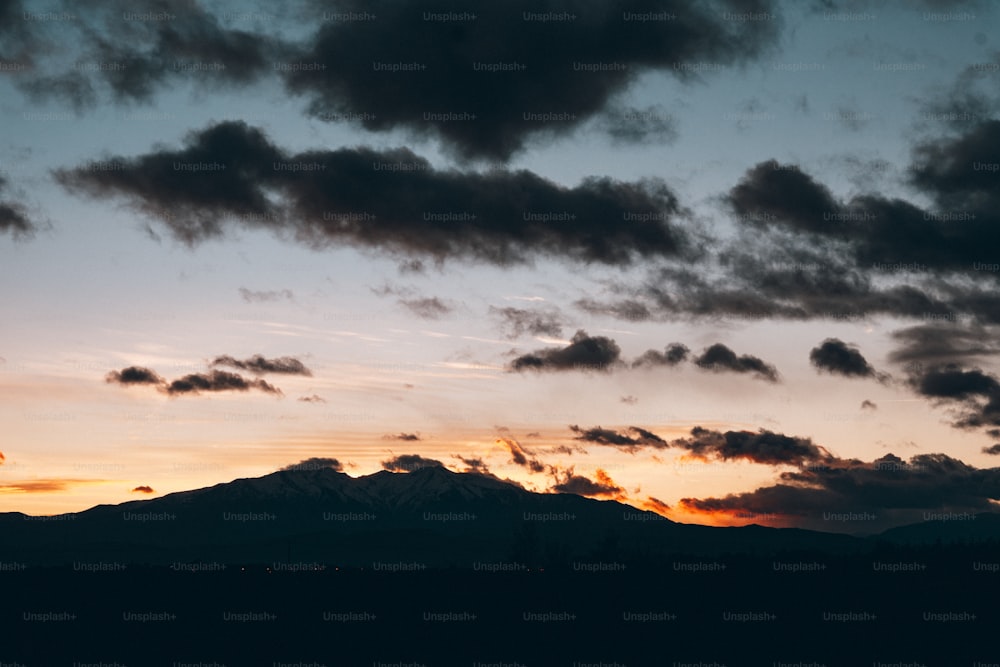 a plane flying in the sky with a mountain in the background