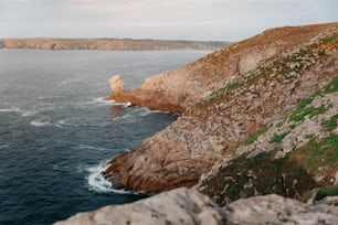 a large body of water near a rocky cliff