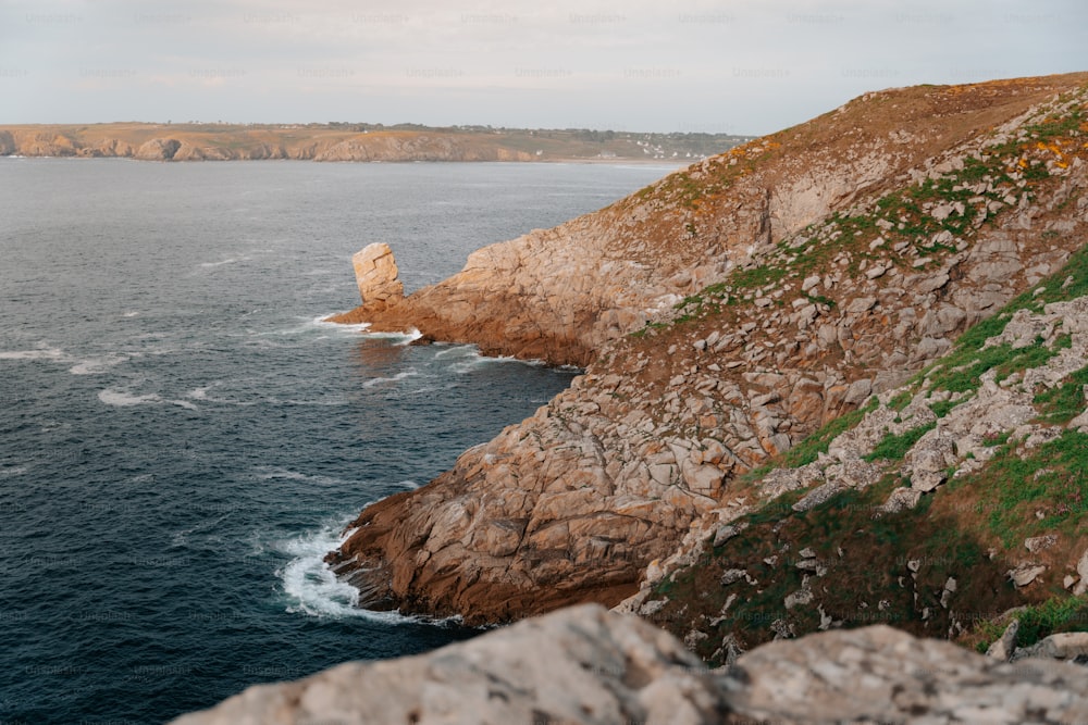 a large body of water near a rocky cliff
