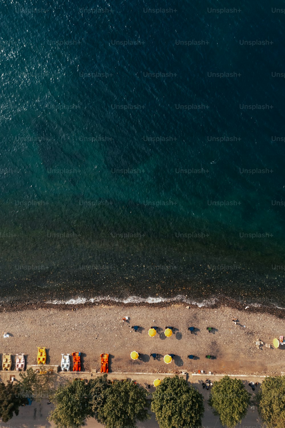 an aerial view of a beach with cars parked on it