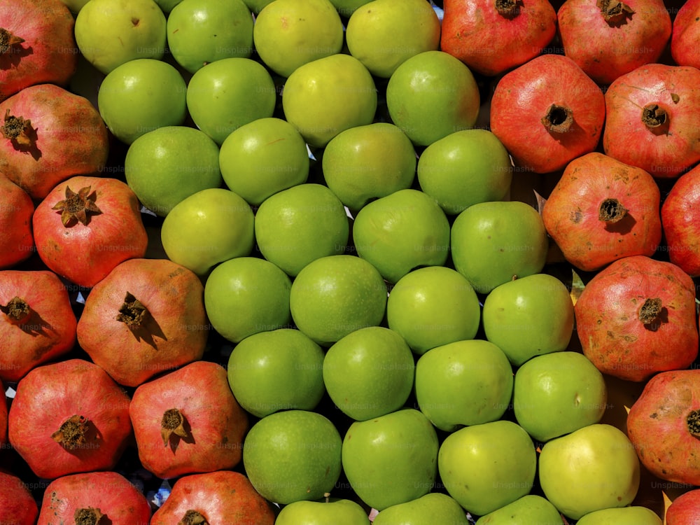 uma pilha de maçãs verdes e vermelhas uma ao lado da outra