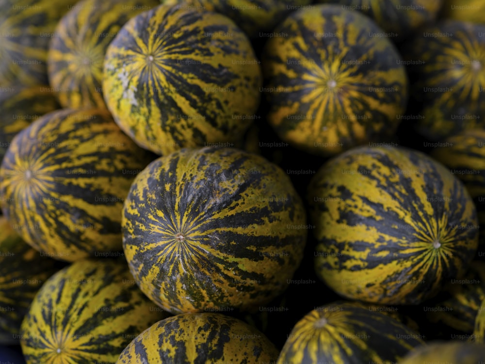a pile of yellow and black watermelons sitting on top of each other