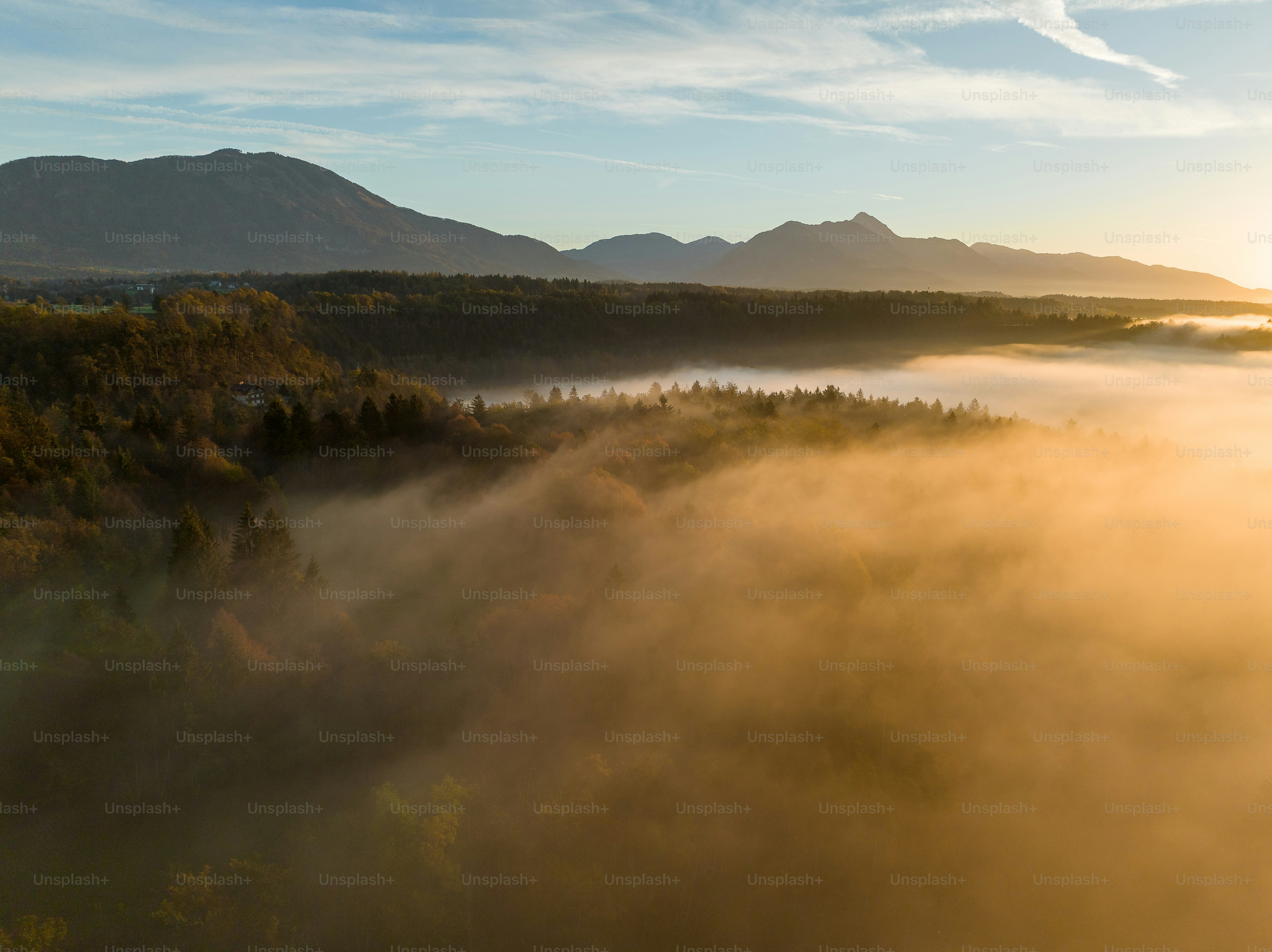the sun is shining through the fog in the valley