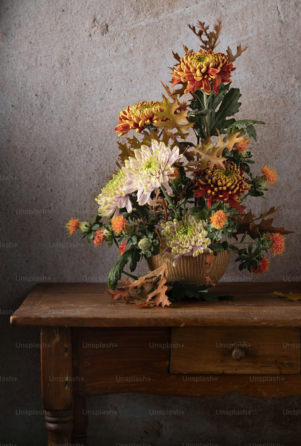 ein hölzerner Tisch mit einer Vase voller Blumen