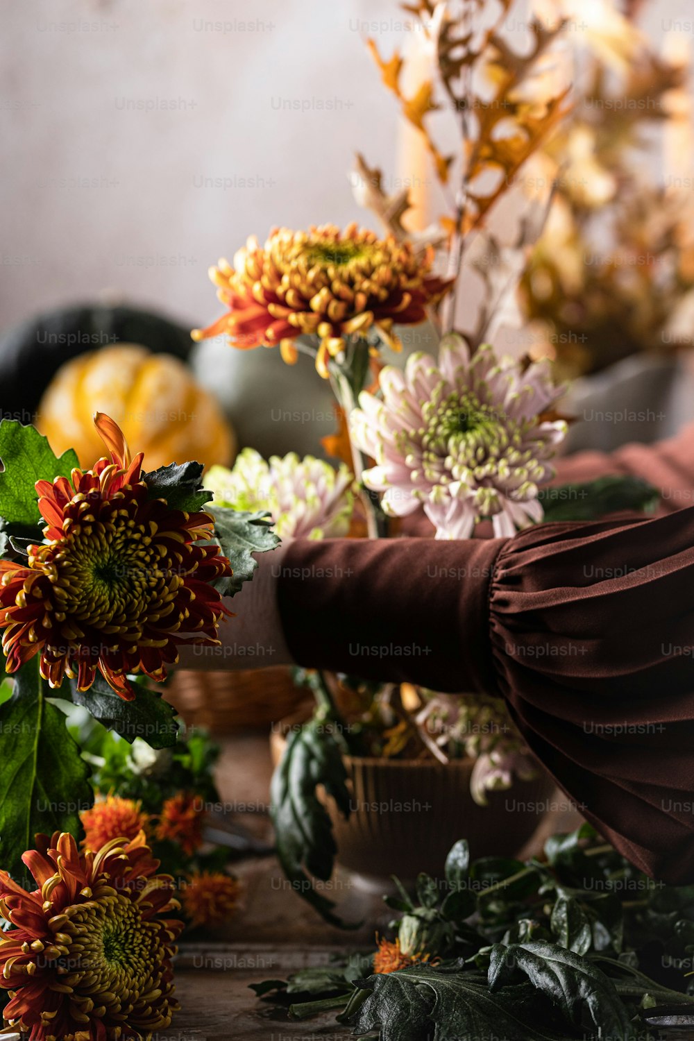 a person arranging flowers on a wooden table