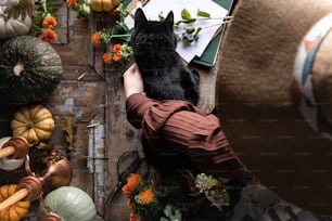 a person holding a black dog in their hands