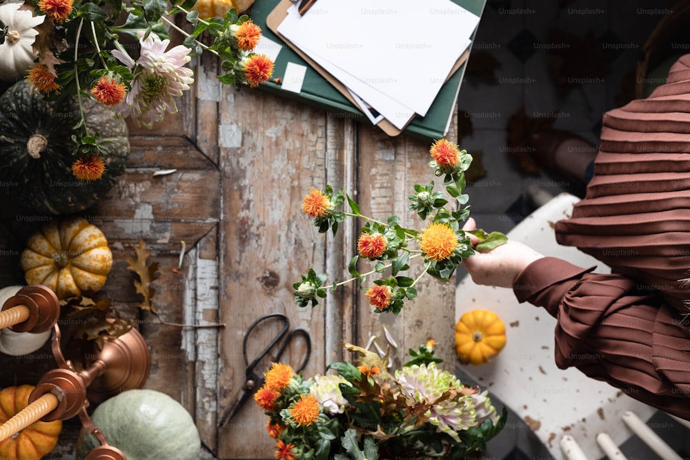 une personne disposant des fleurs sur une table