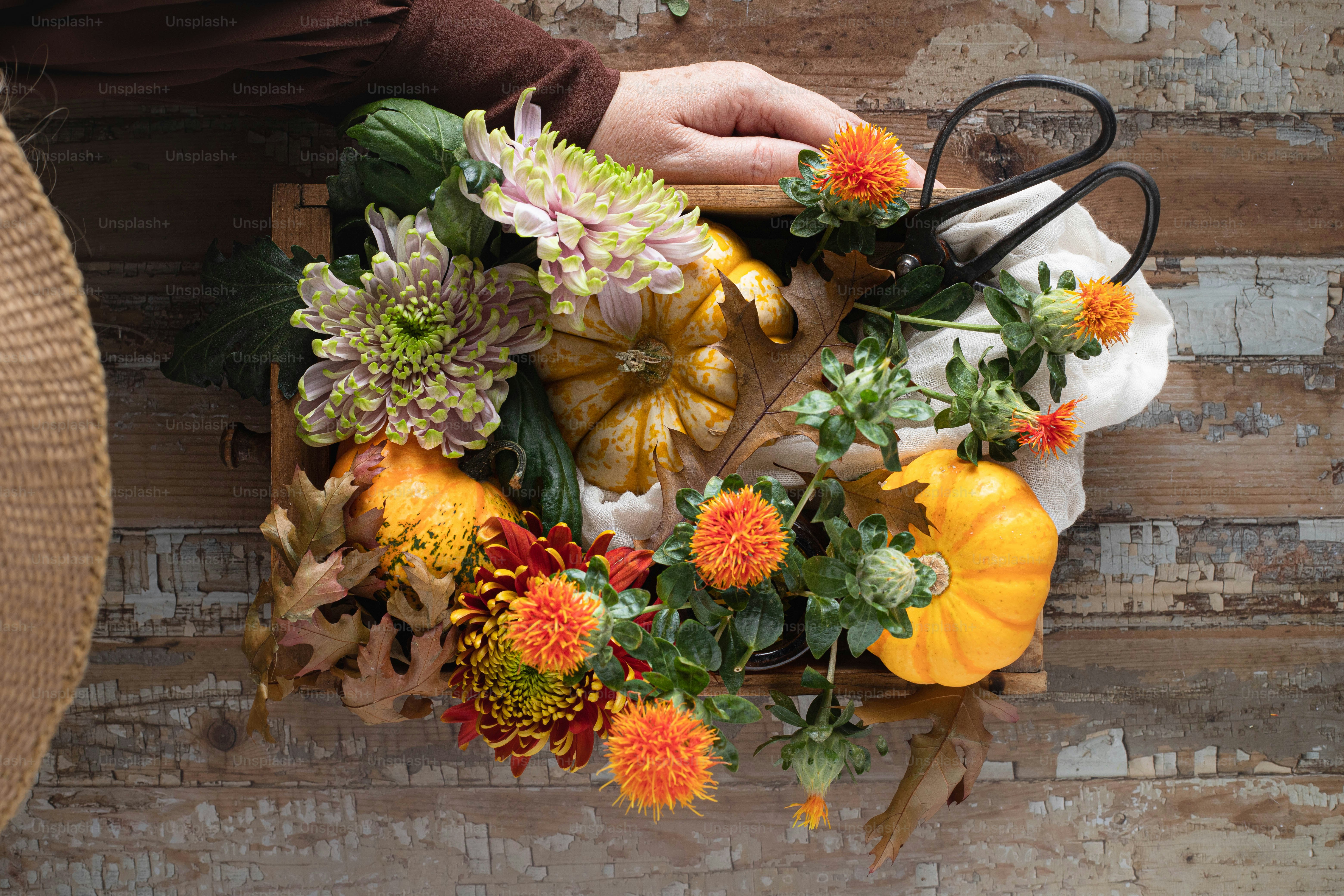 une personne tenant une paire de ciseaux sur un bouquet de fleurs