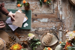 Una persona sosteniendo un pedazo de papel cerca de un ramo de flores