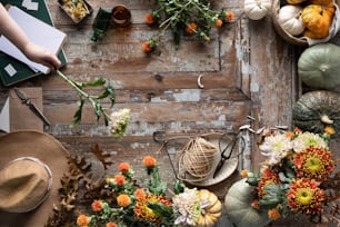 a wooden table topped with lots of different types of flowers