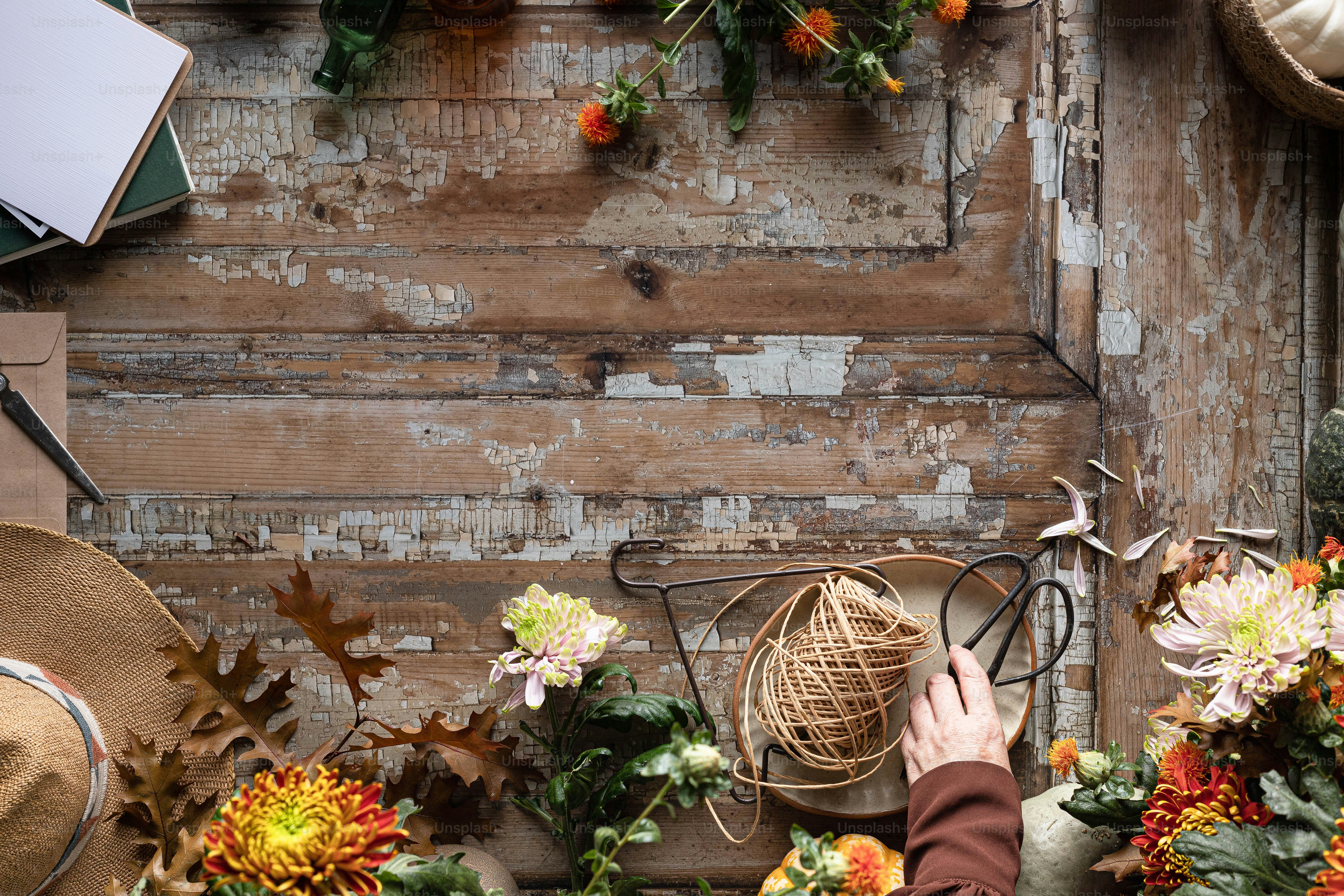 une personne disposant des fleurs devant un mur en bois