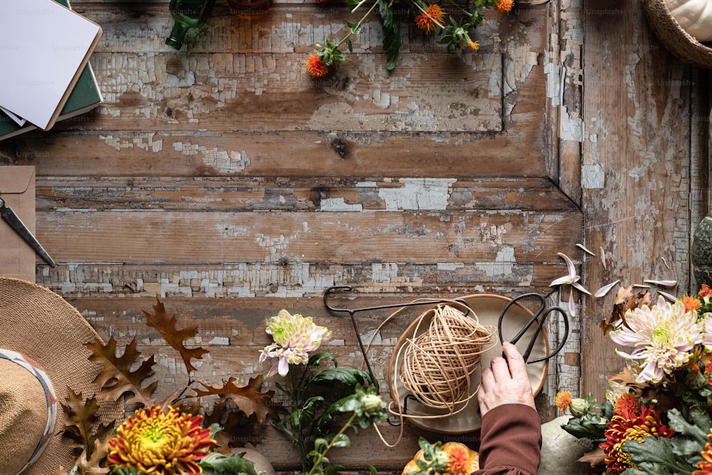 a person arranging flowers in front of a wooden wall