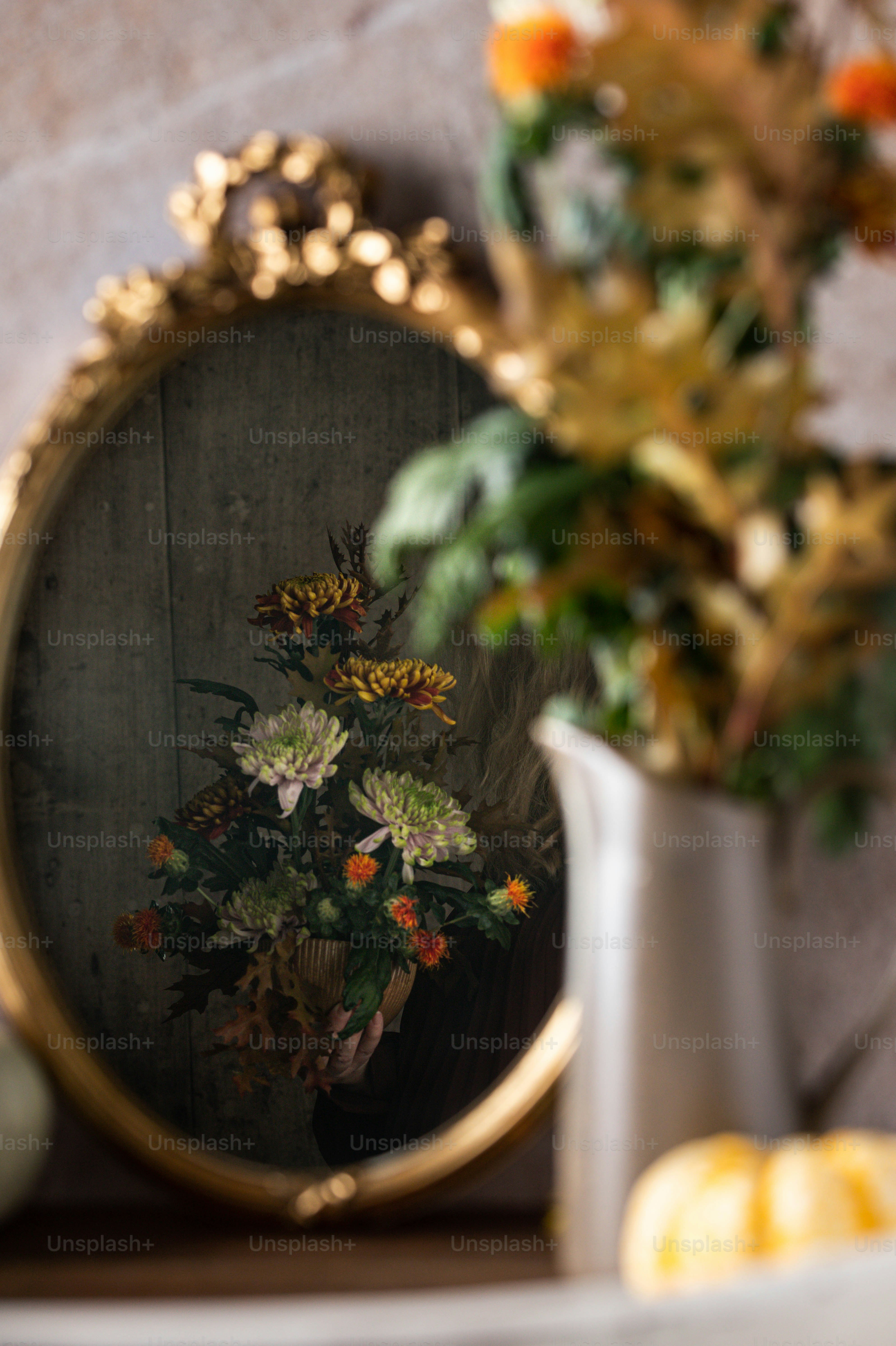 um vaso de flores sentado ao lado de um espelho