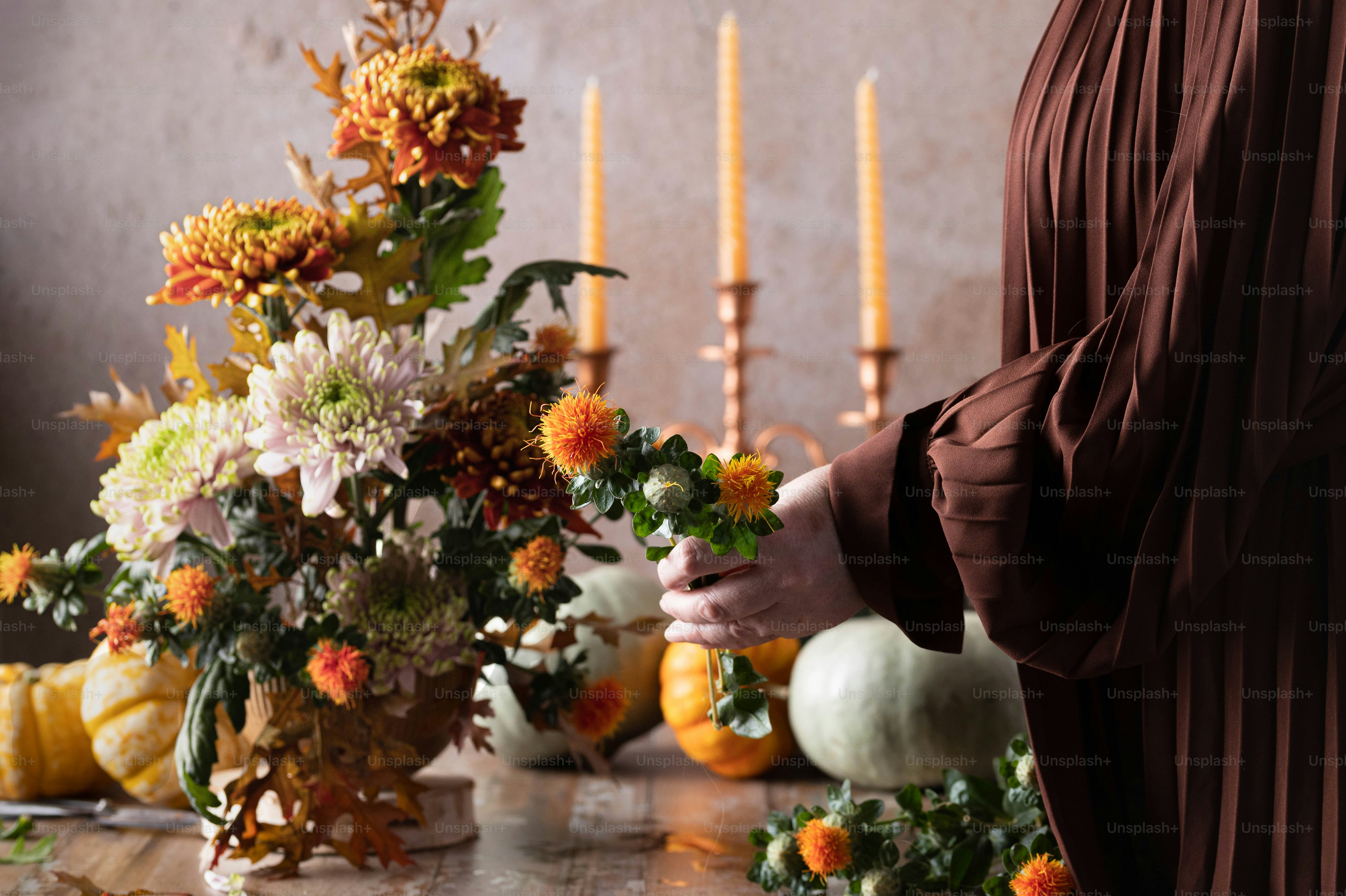 a woman is arranging flowers on a table