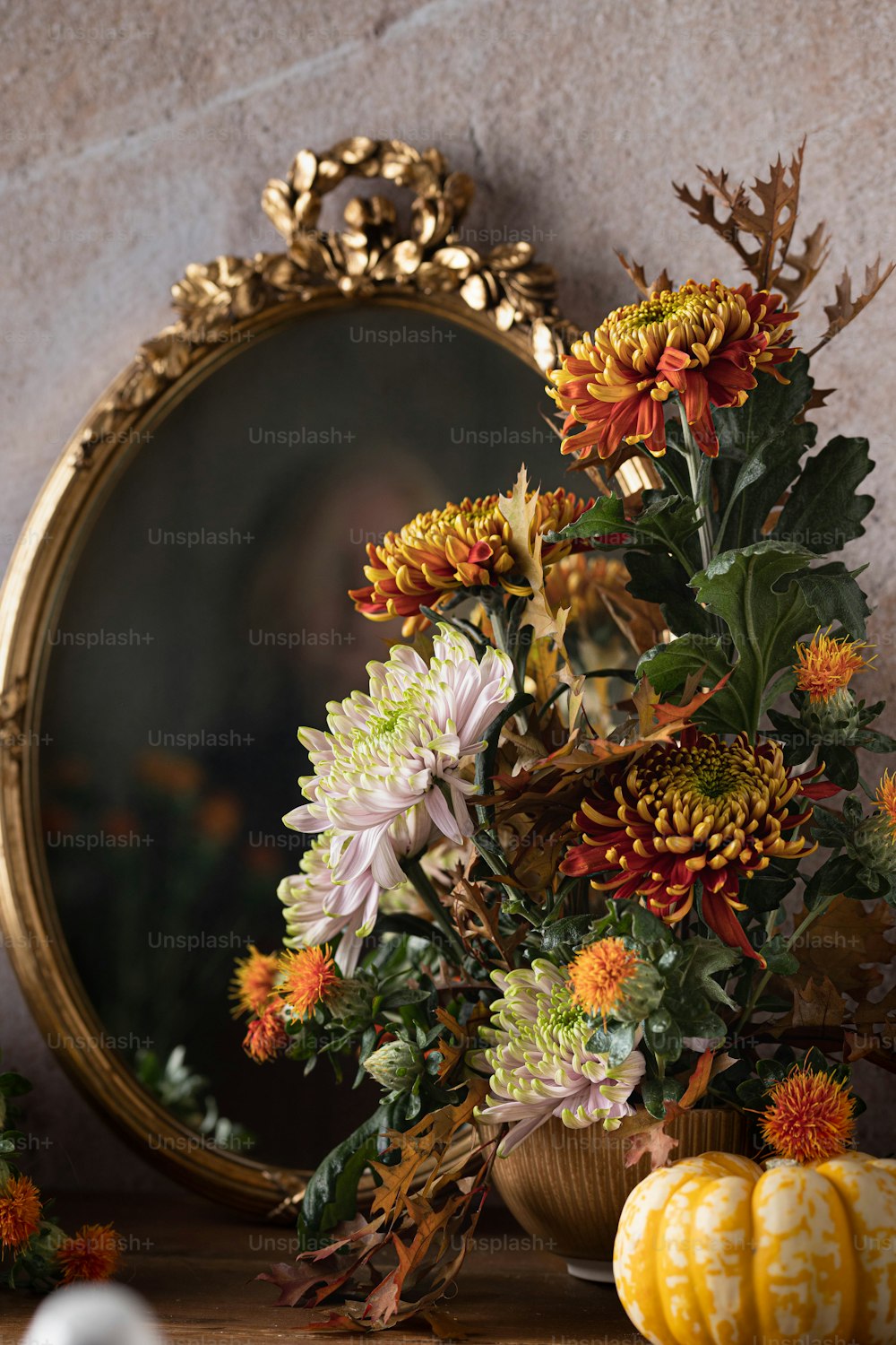Un jarrón de flores sentado junto a un espejo