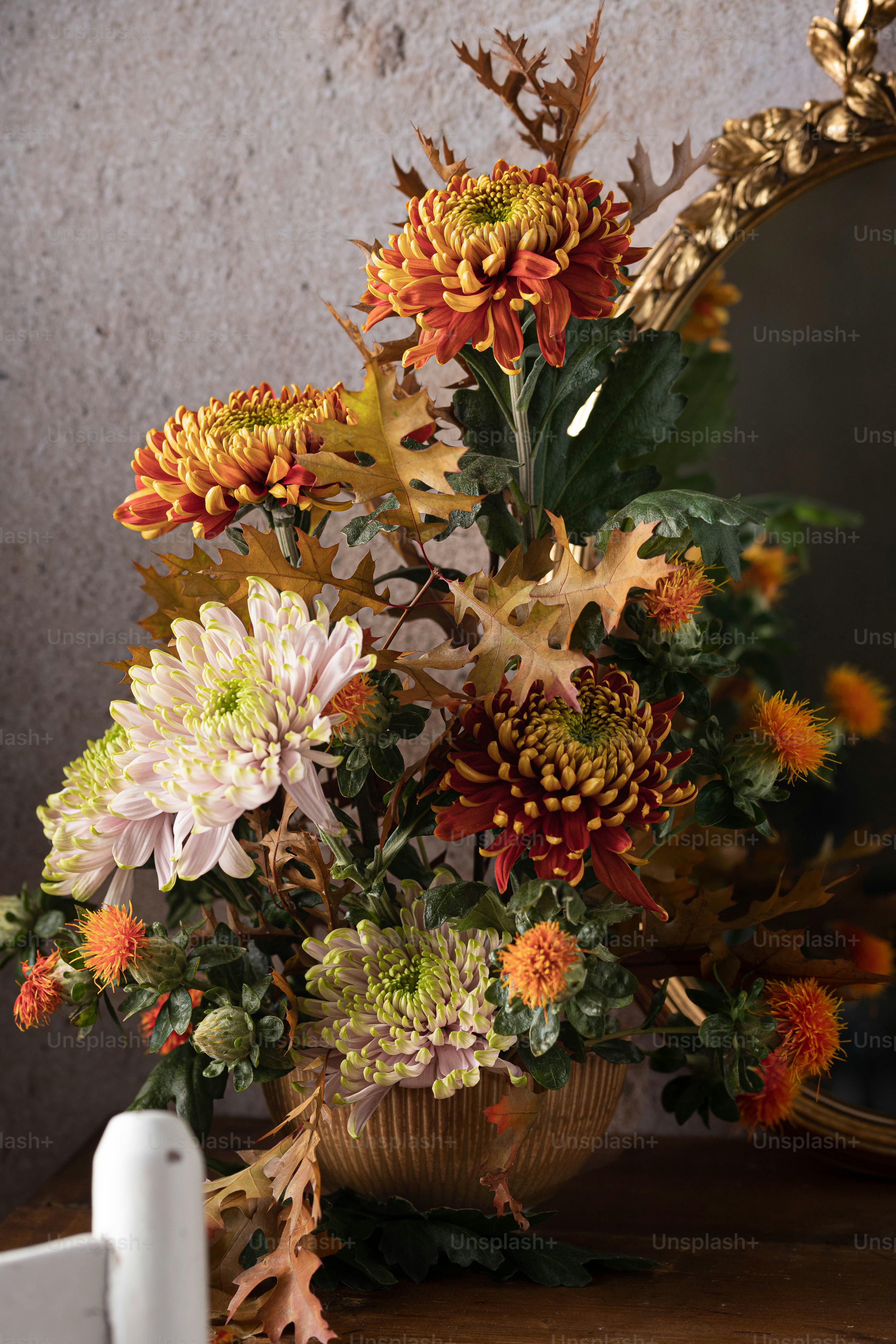 Un vase rempli de beaucoup de fleurs à côté d’un miroir