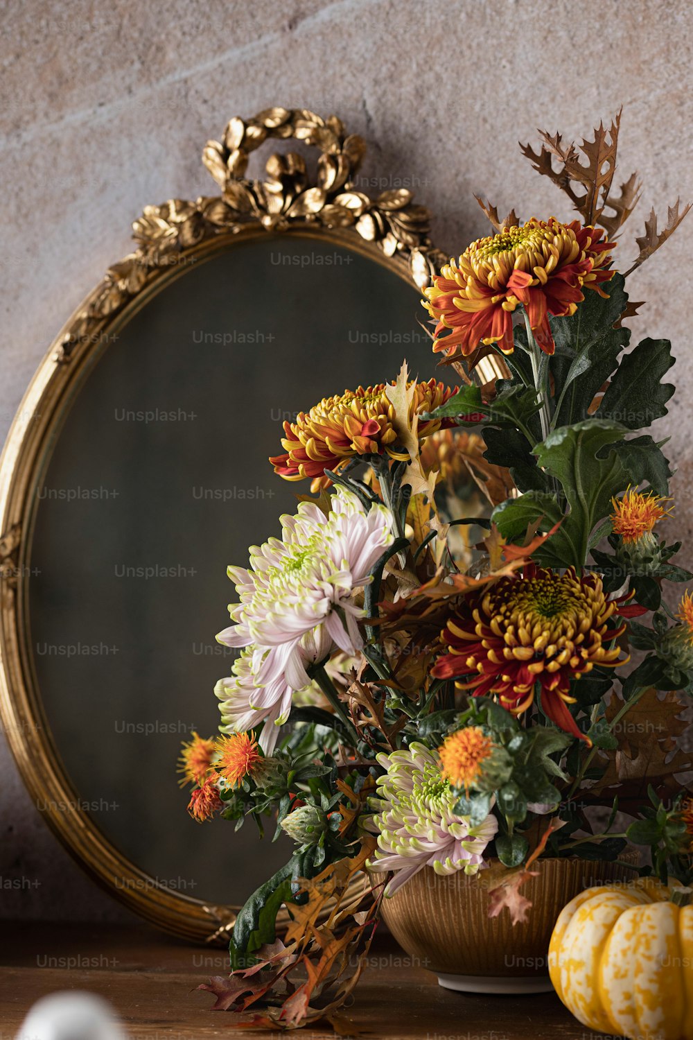 eine Vase mit Blumen, die neben einem Spiegel sitzt